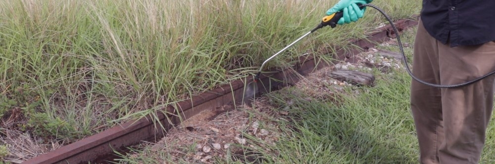 Spraying bare ground herbicide on railroad weeds